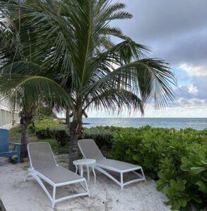 Antigua; a beautiful view of the beach and tropical trees with inviting lounge chairs